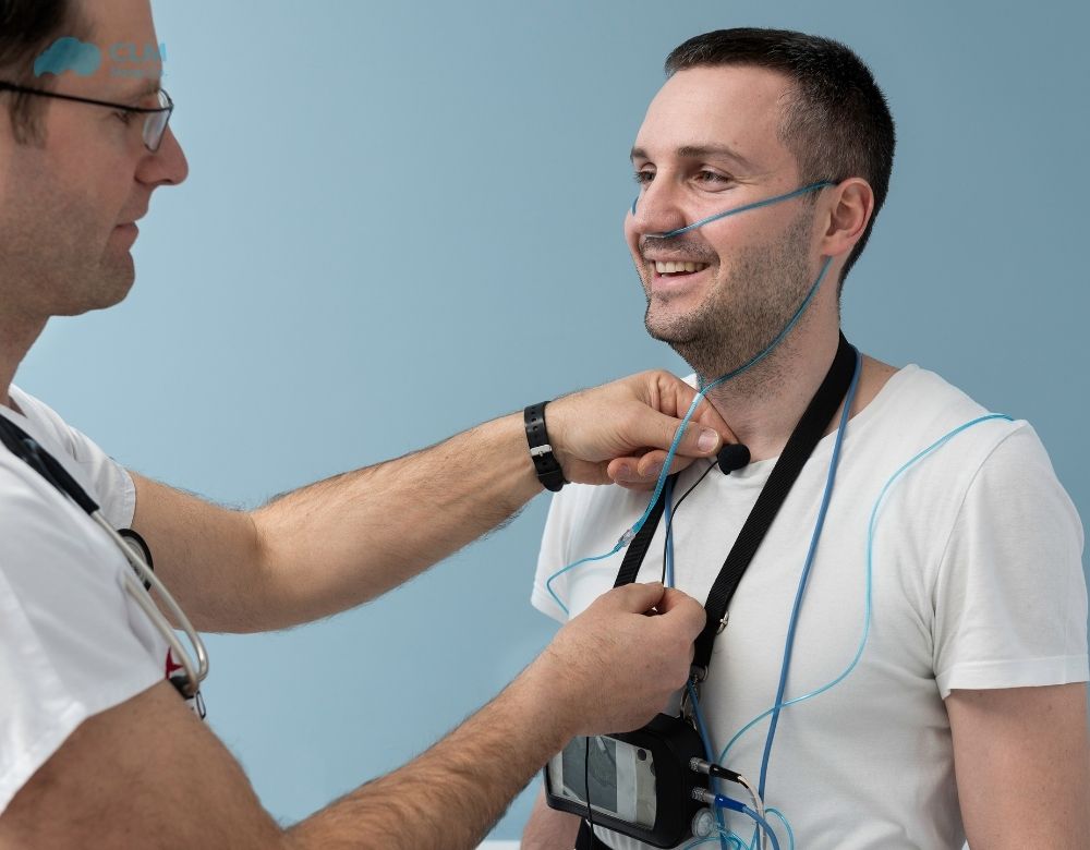 The doctor is setting up the sleep study equipment.